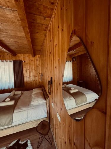 a mirror in a cabin with two beds in it at Vila Shkalla in Theth