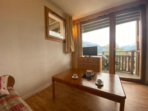 - un salon avec une table basse et une grande fenêtre dans l'établissement Nid douillet avec superbe vue à 100m des pistes, à Villarodin-Bourget