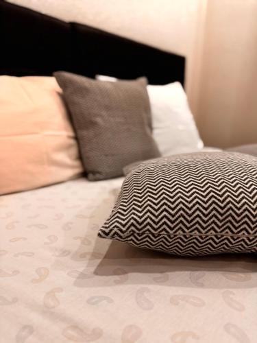 a bed with a black and white pillow on it at Guest House deluxe in Orašje