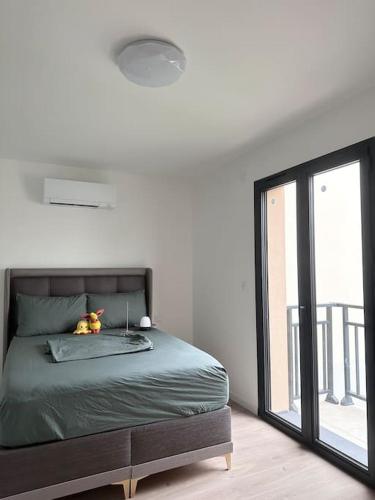 une chambre avec un lit et une grande fenêtre dans l'établissement Maison familiale moderne aux portes de Paris, à Vitry-sur-Seine