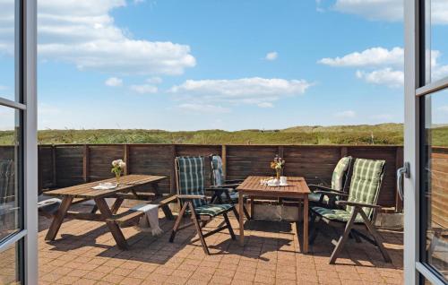 a patio with tables and chairs on a balcony at Three-Bedroom Holiday Home In Ulfborg in Ulfborg