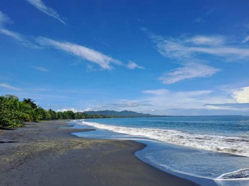 a beach with black sand and the ocean at Luz Tropical in Puerto Viejo