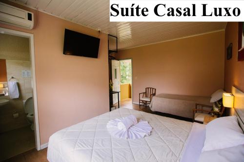 a bedroom with a white bed with a pillow on it at Pousada São Chico Eco Village in São Francisco de Paula