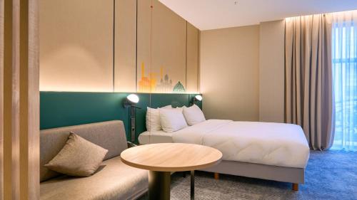 a hotel room with a bed and a table at Holiday Inn Tashkent City by IHG in Tashkent