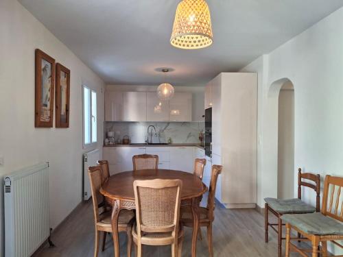 une cuisine et une salle à manger avec une table et des chaises dans l'établissement Serenity - Maison avec jardin et parking, à Saint-Denis