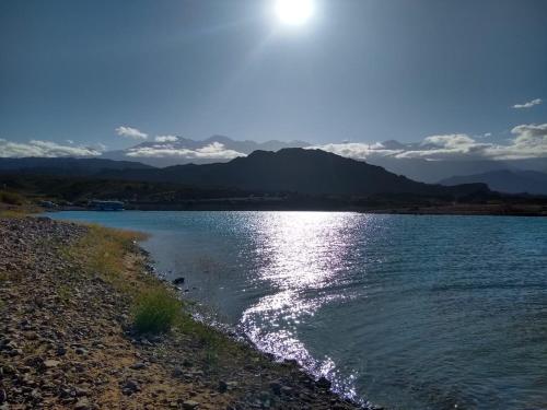 a body of water with the sun shining on it at Cabaña Sonnentahl 1 in Potrerillos