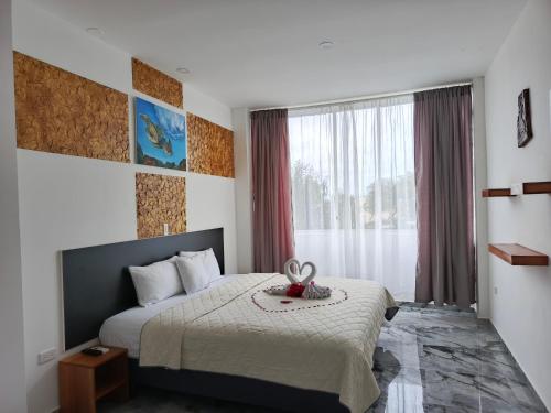 a hotel room with a bed and a window at Patty House Galapagos in Puerto Ayora