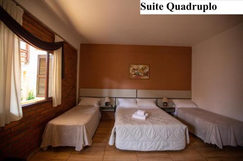 a room with two beds and a window at Pousada São Chico Eco Village in São Francisco de Paula