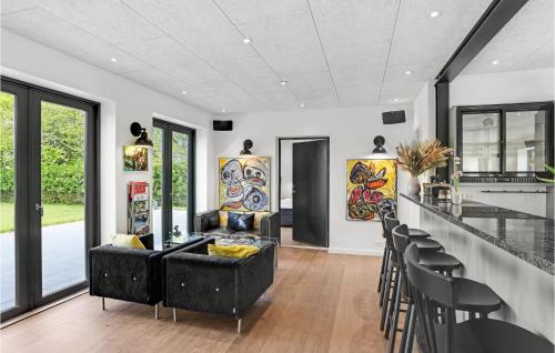 a living room with a black couch and a bar at Gubbegård in Neksø