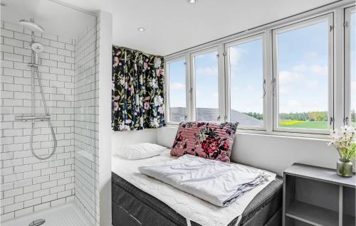 a bathroom with a bed and a shower and windows at Gubbegård in Neksø