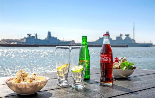 a table with two bottles and a bowl of food and drinks at Amazing Apartment In Korsør in Korsør