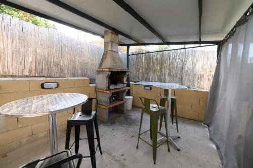 a outdoor kitchen with a stove and tables and chairs at VILLA Formonte in Los Ángeles de San Rafael