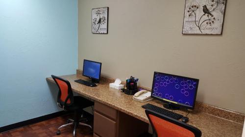 a desk with a computer and two monitors on it at Candlewood Suites Oklahoma City-Moore by IHG in Moore