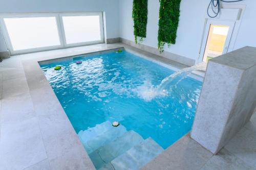 a swimming pool with blue water in a room at VILLA Formonte in Los Ángeles de San Rafael