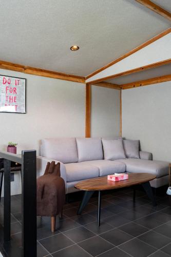 a living room with a couch and a table at The Jardin in Kami-furano