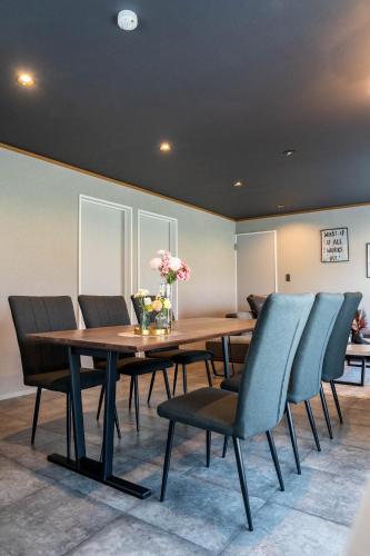 a dining room with a wooden table and chairs at The Jardin in Kami-furano