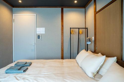 a bedroom with a bed with white sheets and pillows at The Jardin in Kami-furano