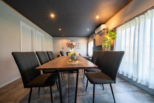 a dining room with a wooden table and chairs at The Jardin in Kami-furano