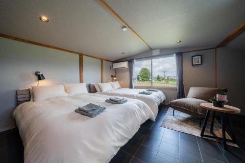 a room with two beds and a couch and a window at The Jardin in Kami-furano