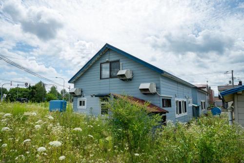 a blue house in the middle of a field at The Jardin in Kami-furano