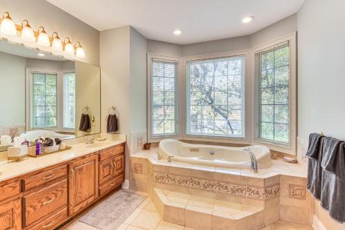 a bathroom with a tub and two sinks and windows at Lakefront Hartwell Retreat with Gas Grill and Deck! in Hartwell
