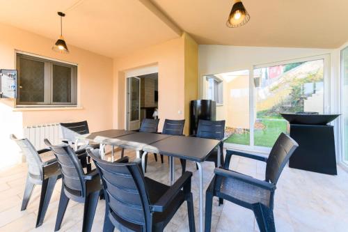 a dining room with a black table and chairs at VILLA Formonte in Los Ángeles de San Rafael