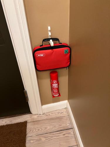 a red suitcase in the corner of a room at Byhuset - Hems 60 in Vejle