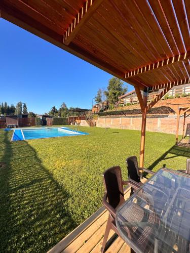 a patio with a table and chairs and a swimming pool at Ecoraleo in Concepción