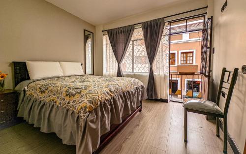 a bedroom with a bed and a large window at Departamento en centro de Cuenca in Cuenca