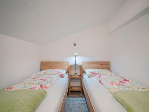 two beds sitting next to each other in a room at Gastl in Hopfgarten im Brixental