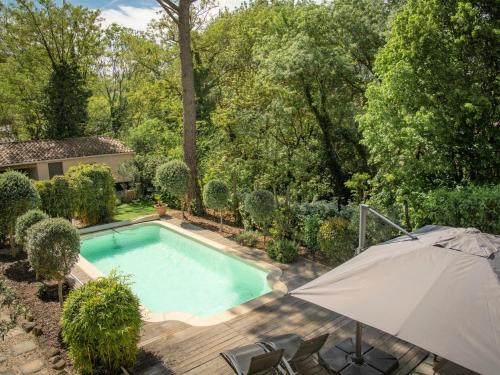 - une vue sur la piscine avec un parasol dans l'établissement Villa Martinet, à Carpentras