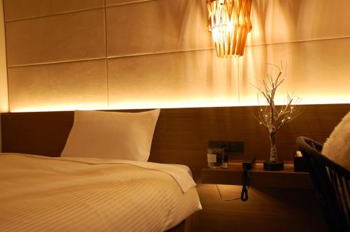 a bedroom with a bed and a chandelier at Hotel Global View Hakodate in Hakodate