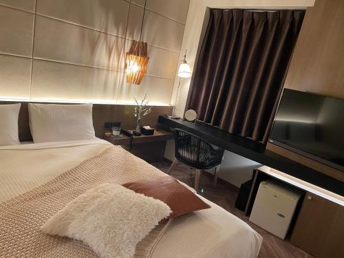 a hotel room with a bed and a television at Hotel Global View Hakodate in Hakodate