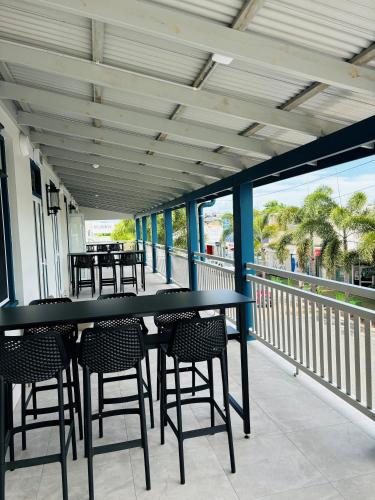 a patio with tables and chairs on a balcony at Palace Hotel Proserpine in Proserpine