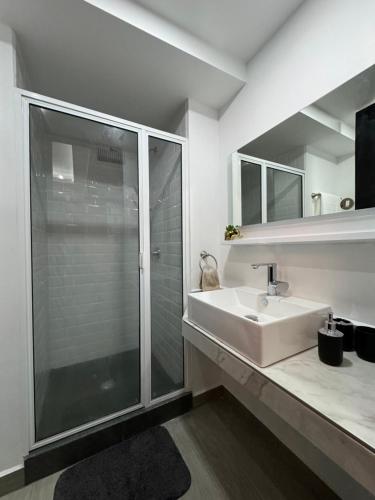 a white bathroom with a sink and a shower at Departamento Elefante in Mexico City