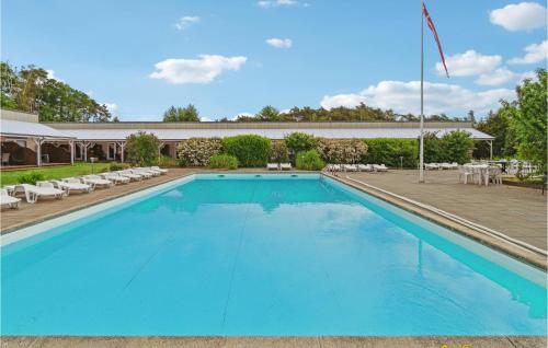 ein großer blauer Pool mit Stühlen und ein Gebäude in der Unterkunft Lovely Apartment In Nexø With Sauna in Neksø
