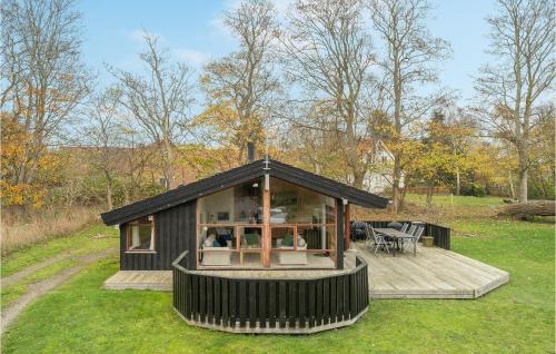a small black house with a deck in the grass at Holiday Home Knold-Åsen H-617 in Vejby