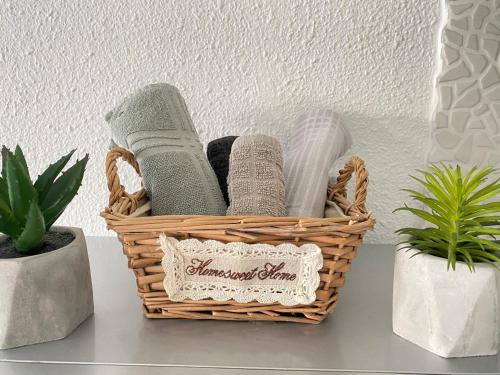 a basket of towels on a shelf with plants at Excellence Suites Orient Beach Oceanview King-Size Beach Pool Parking in Cul de Sac