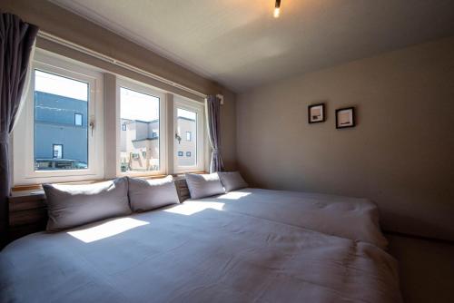 a large bed in a room with two windows at The Chateau in Yoichi