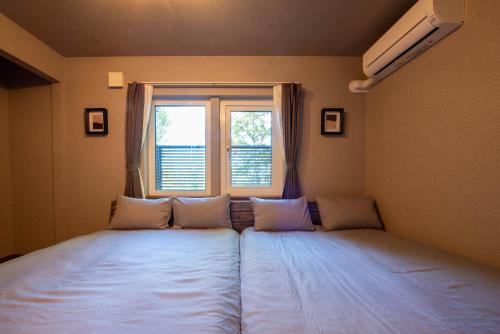 a bed in a room with a window at The Chateau in Yoichi