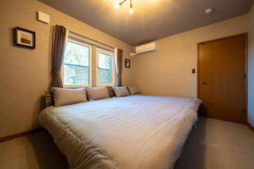 a large bed in a room with a window at The Chateau in Yoichi
