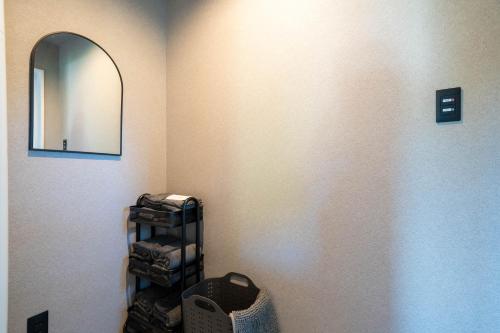 a bathroom with a mirror and a shelf with towels at The Chateau in Yoichi