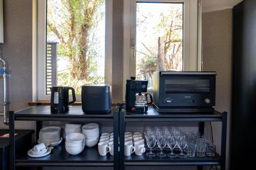 a counter with a microwave and a television and glasses at The Chateau in Yoichi