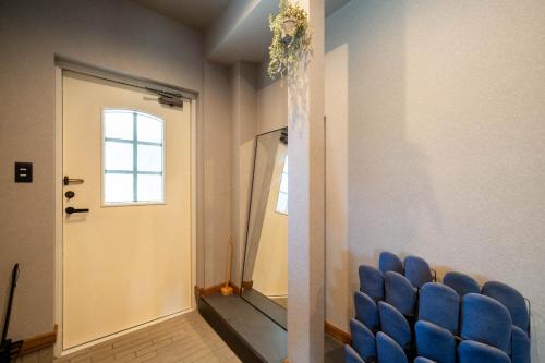 a row of blue chairs in a hallway with a door at The Chateau in Yoichi