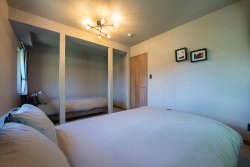 a bedroom with a white bed and a mirror at The Chateau in Yoichi