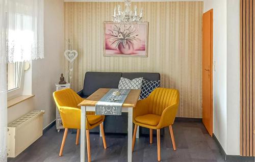 a dining room with a table and yellow chairs at Ferienwohnung Rheinsberg in Kunkelberg