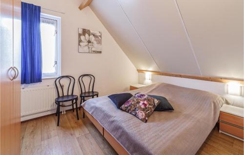 a bedroom with a bed and two chairs in it at Awesome Home In Wemeldinge With Kitchen in Wemeldinge
