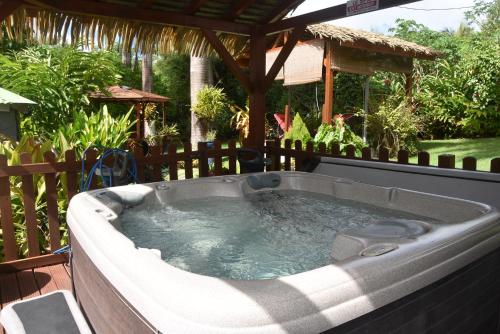 a hot tub on a patio with a gazebo at Gite d'Arles Bungalow "Ti Polo" in Le Moule