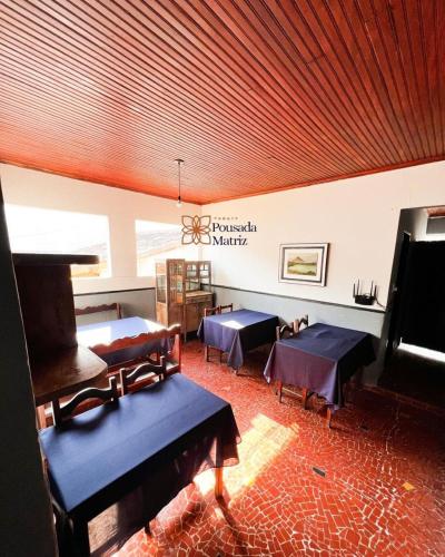 a room with tables and a piano in a room at Pousada Matriz in Paraty