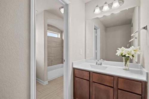 a bathroom with a sink and a vase of flowers at Gated Community 2-story Home2 in Rosenberg